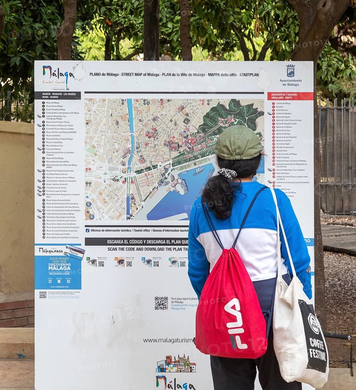 Person looking at plan map of city centre of Malaga, Andalusia, Spain showing locations of main tourist attractions