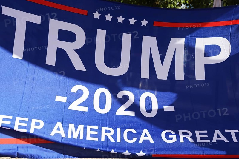 Convinced Trump supporters in Germany hold up a banner with the campaign slogan Trump 2020 - keep America great