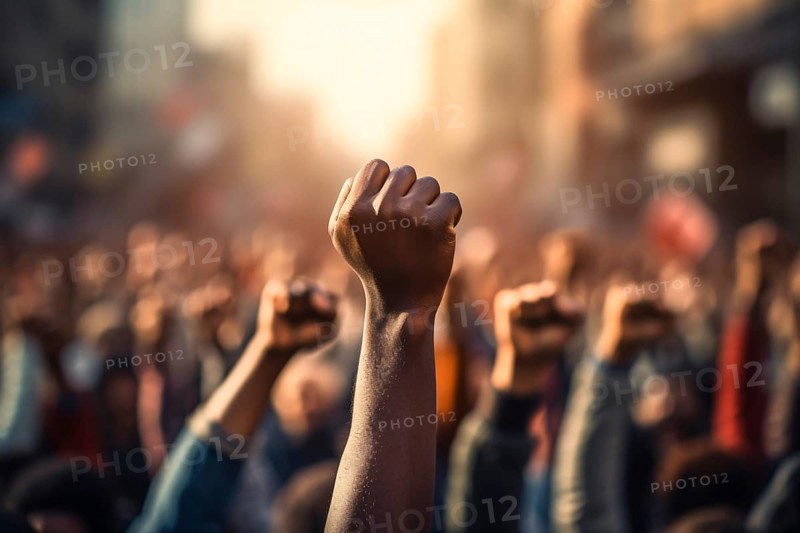 Raised fist of afro american man in large angry protest riot crowd of people in blurry background. KI generiert, generiert AI generated