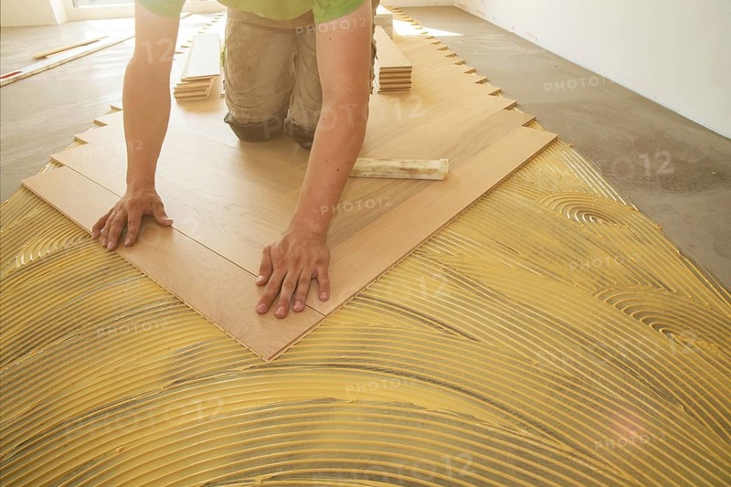 Craftsmen laying herringbone parquet professionally