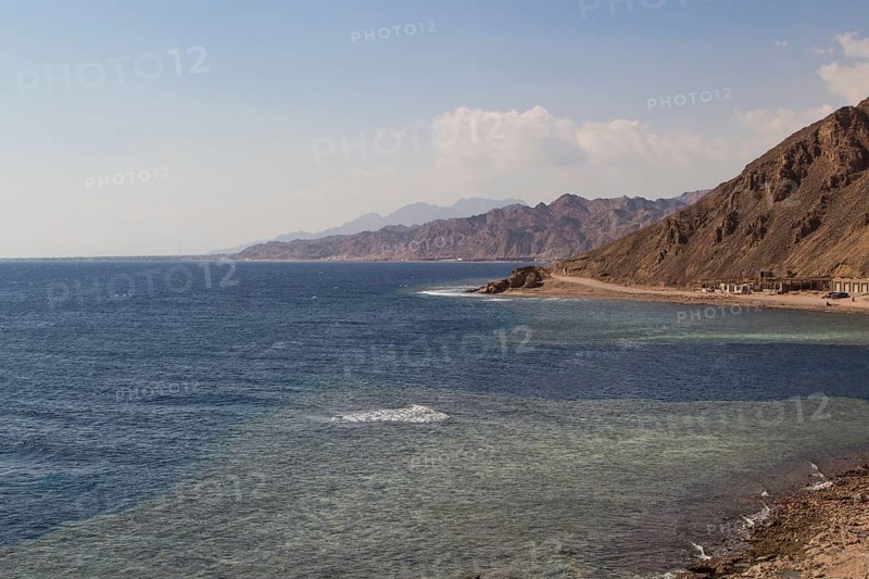 The coastline of the Red Sea with small resorts and the mountains in the background. Coral reef Blue Hole. Egypt, the Sinai Peninsula, Dahab