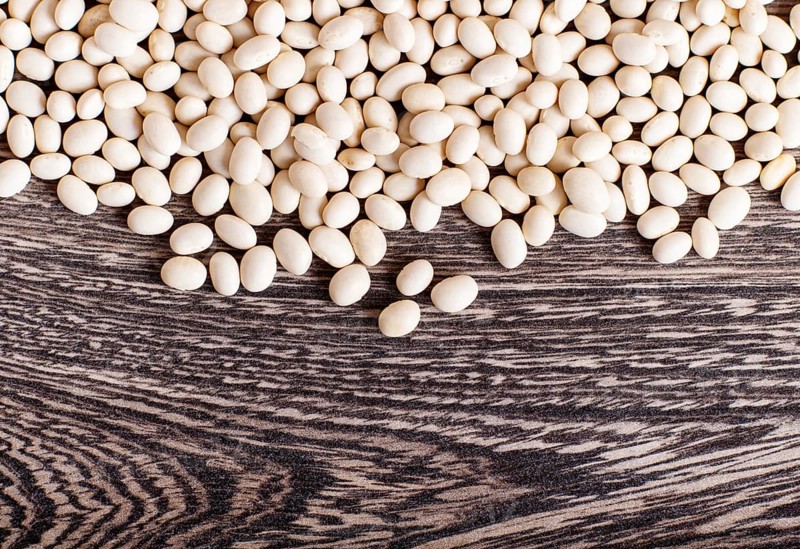 Texture of white beans isolated on a gray wooden background. Closeup