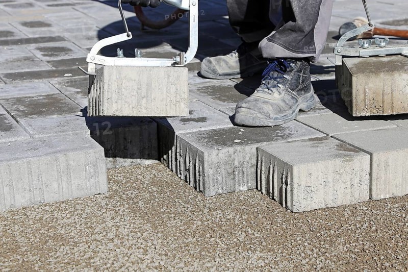 Workers lay paving stones
