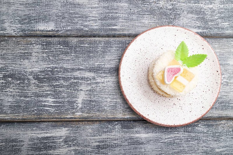 Decorated cake with milk and coconut cream on a gray wooden background. top view, flat lay, copy space