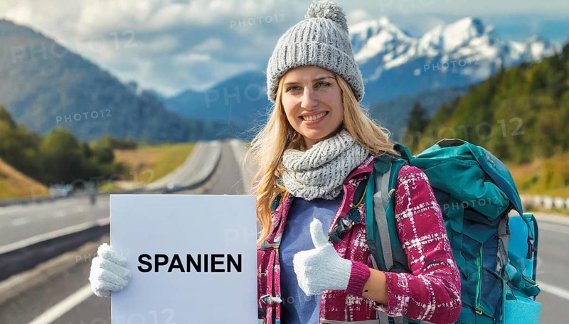 AI generated, human, humans, person, persons, woman, woman, one person, 20, 25, years, outdoor, seasons, cap, bobble hat, gloves, winter jacket, cold, cold, backpack, woman wants to travel, hitchhiking, hitchhiking, hitchhiking, road, motorway, sign saying Spain