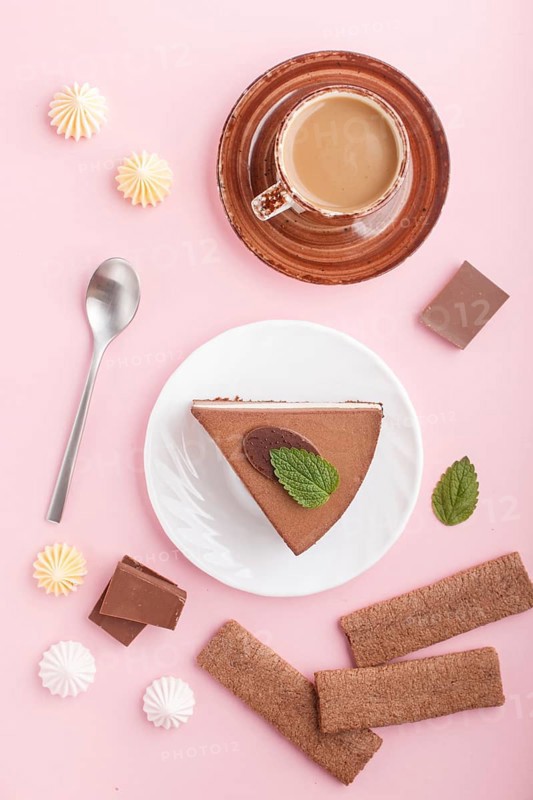 Cake with souffle milk chocolate cream with cup of coffee, meringues on a pink pastel background. top view, flat lay, close up. breakfast concept