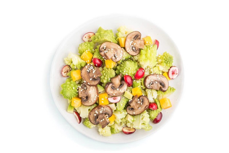 Vegetarian salad from romanesco cabbage, champignons, cranberry, avocado and pumpkin isolated on a white background. top view, close up, flat lay