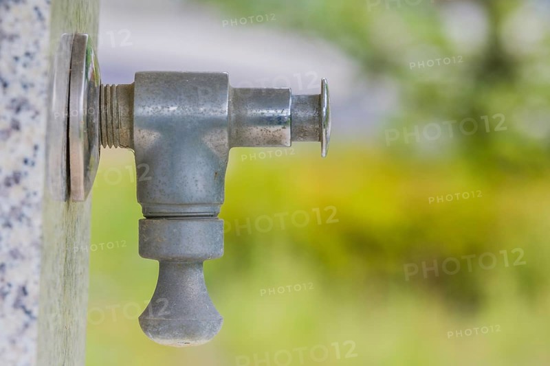 Closeup of water faucet on marble water fountain in public park in South Korea