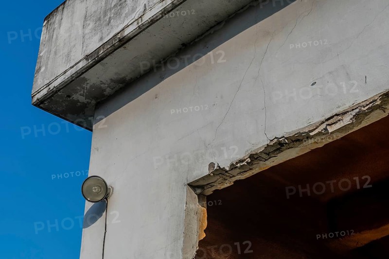 Flood light mounted on outside wall of abandoned concrete building with blue sky in background in South Korea