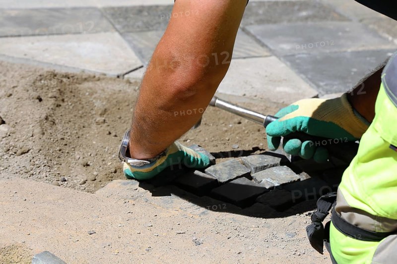 Worker lays paving stones