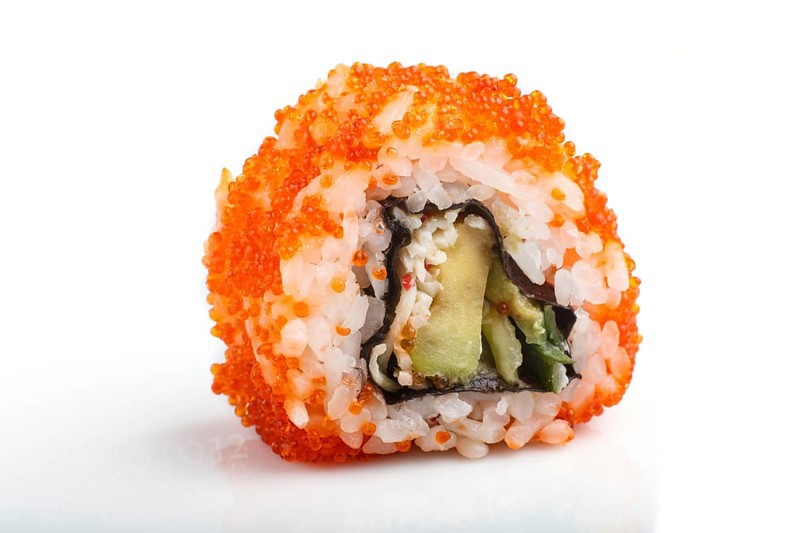 Japanese maki sushi rolls with flying fish roe isolated on white background. Side view, close up, selective focus