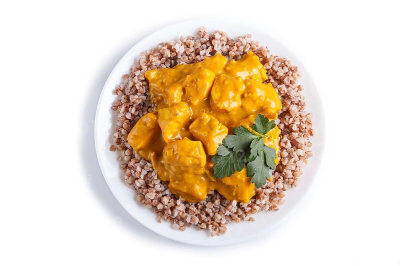 Buckwheat with chicken curry sauce isolated on white background. top view