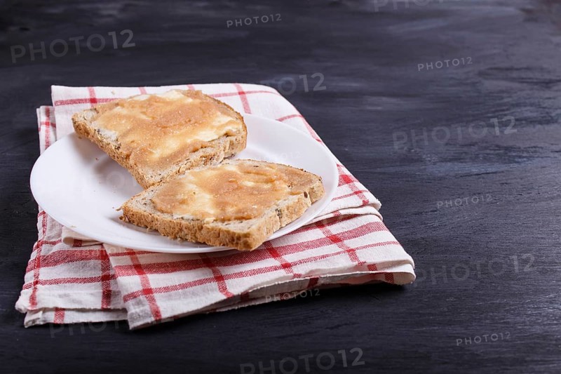 Sandwiches with pollock roe on a white plate, on a black background, with copy space