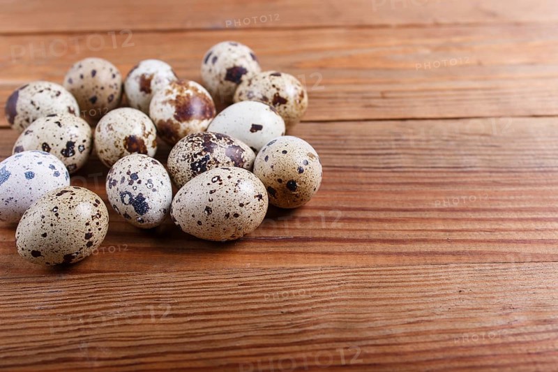 Raw quail eggs on a brown wooden background. with copy space