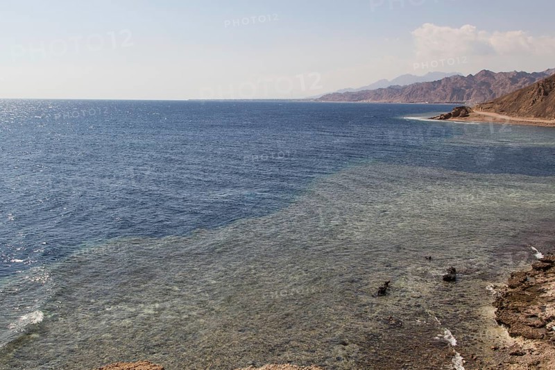 The coastline of the Red Sea with small resorts and the mountains in the background. Coral reef Blue Hole. Egypt, the Sinai Peninsula, Dahab