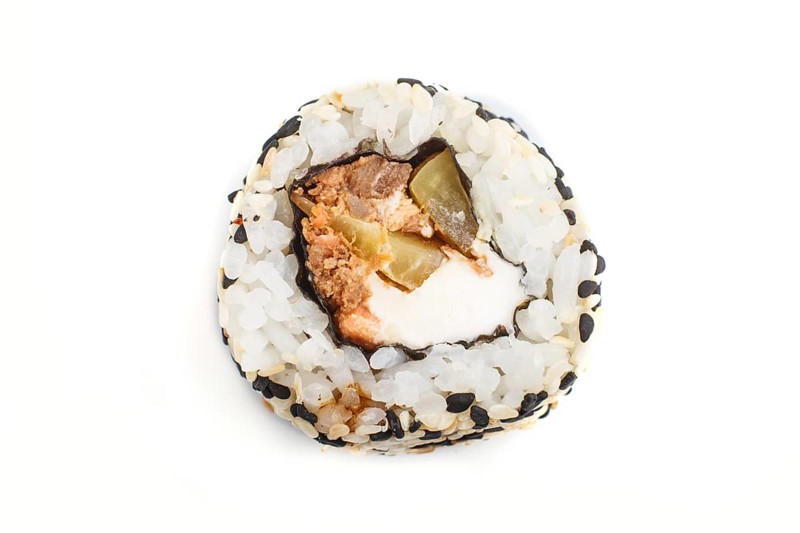 Japanese maki sushi rolls with salmon, sesame, cucumber isolated on white background. Top view, close up, selective focus
