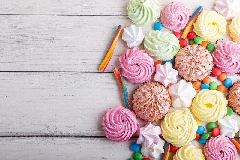 Mixed multicolored candies on white wooden background. copy space, top view, flat lay