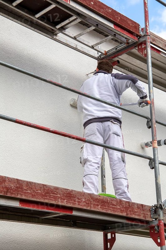 Painter painting the facade of a new residential building