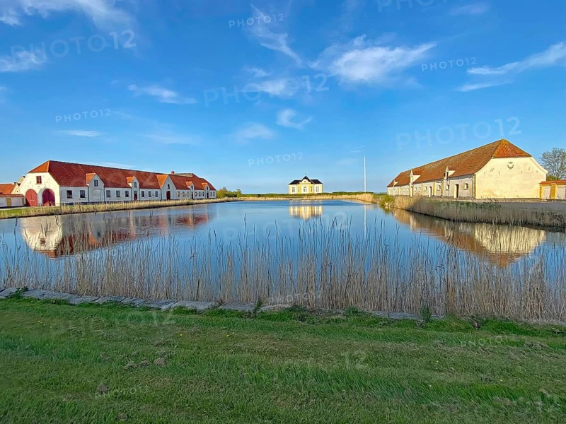 Large houses and the teahouse at Valdemars Slot are reflected in the calm water, Valdemars Slot, Manor Route, Tasinge, Denmark, Europe
