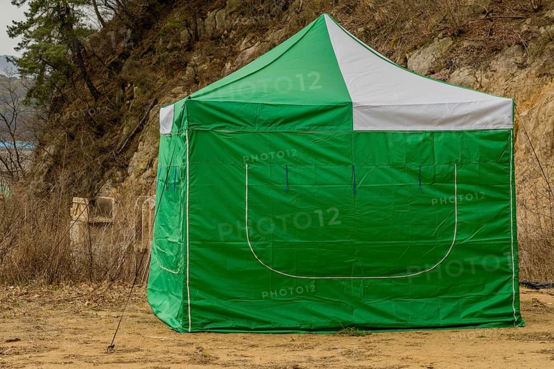 Closeup of green and white canvas tent on bare ground in South Korea