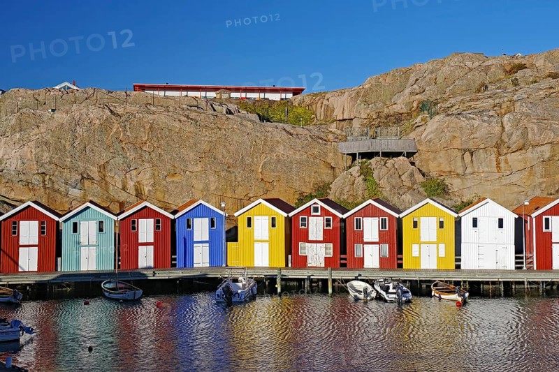 Colourful fishermen's huts nestled against high cliffs, archipelago coast, Smoegen, Vaestra Goetalands Laen, Sweden, Europe