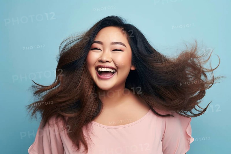 Lauging happy plus size curvy Asian woman in front of blue studio background. KI generiert, generiert AI generated