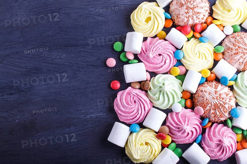 Mixed multicolored candies on black wooden background. copy space, top view, flat lay