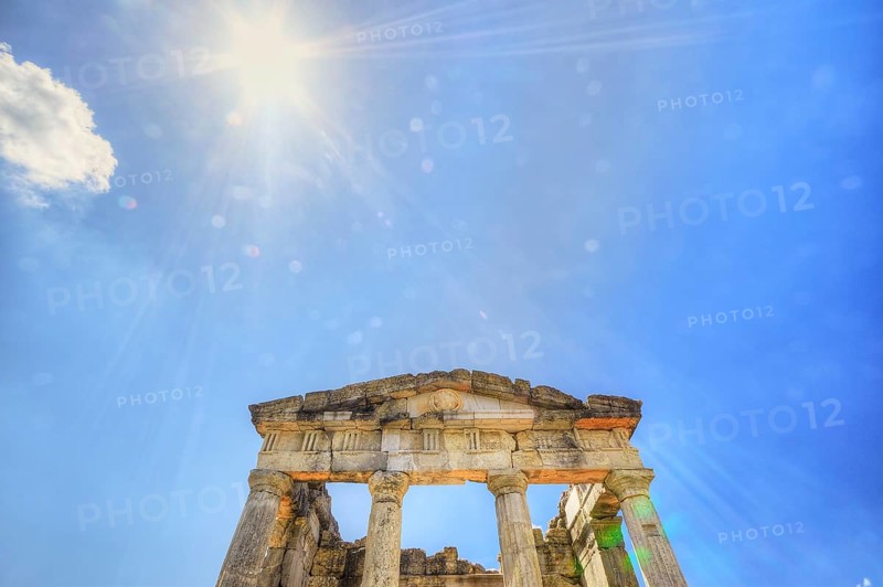 Sunshine pierces the ruins of an ancient temple with columns against a blue sky, Mausoleum, Heroon, Archaeological Site, Ancient Messene, Capital of Messinia, Messini, Peloponnese, Greece, Europe