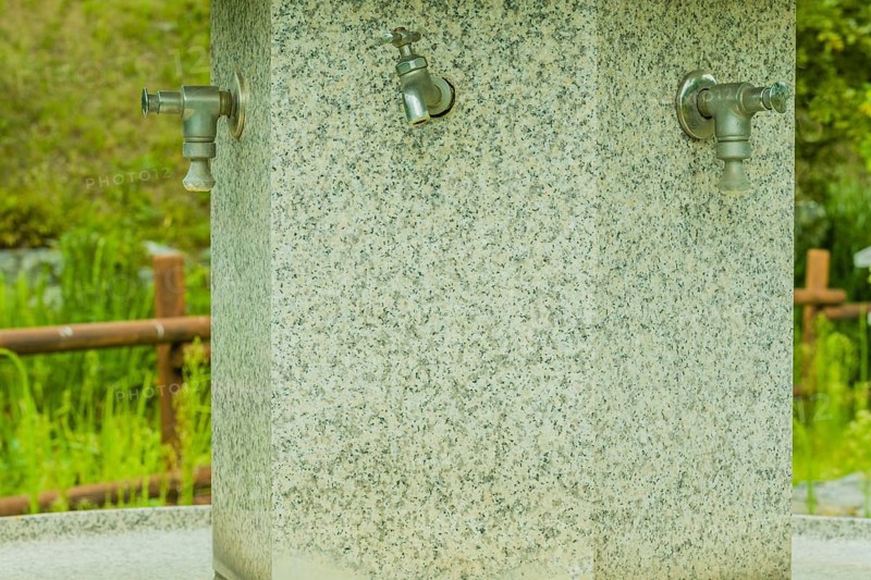 Large hand washing water fountain in a public park with lush green foliage in South Korea