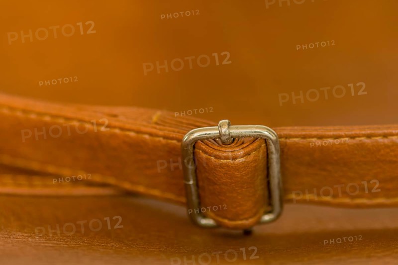 Metal adjustment clip on strap of leather shoulder bag
