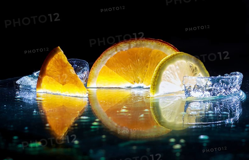 Transparent slices of fresh oranges and lemons on the glass with ice