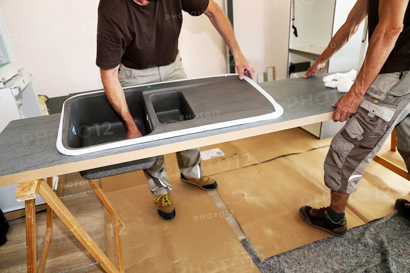Craftsmen installing a new kitchen (kitchen assembly)
