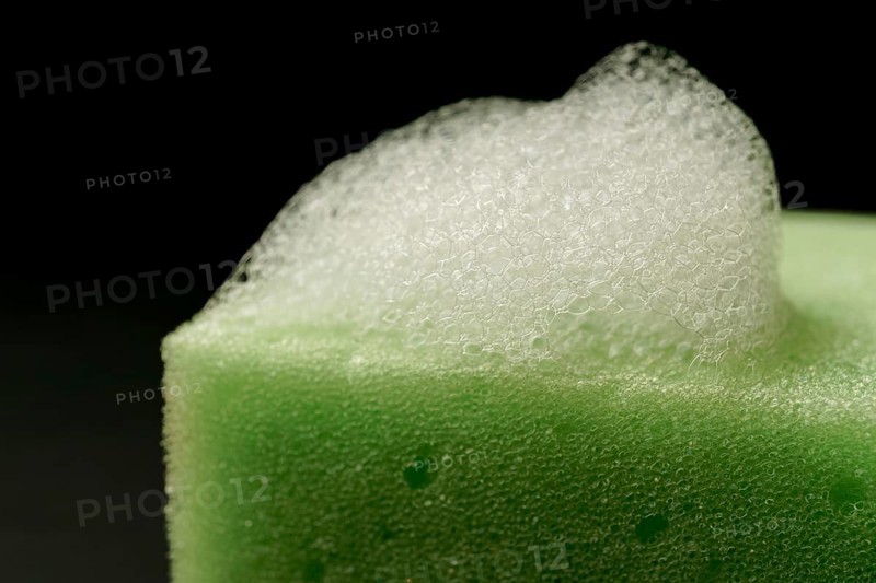 Foam on a green sponge isolated on black background and copy space