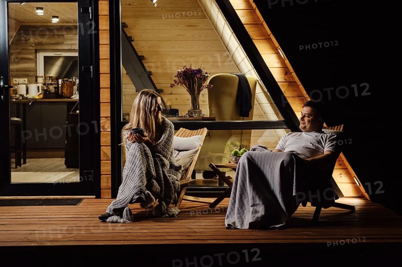 An evening conversation between a friendly couple on the terrace of tiny house