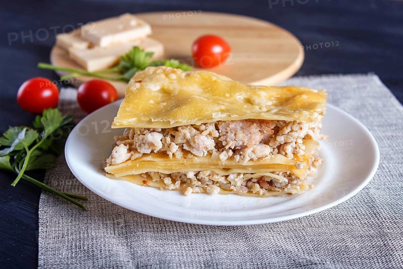 Lasagna with minced meat and cheese on black wooden background. close up