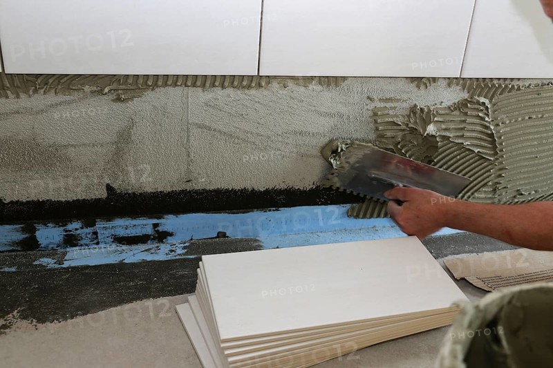 Tiler lays modern wall tiles
