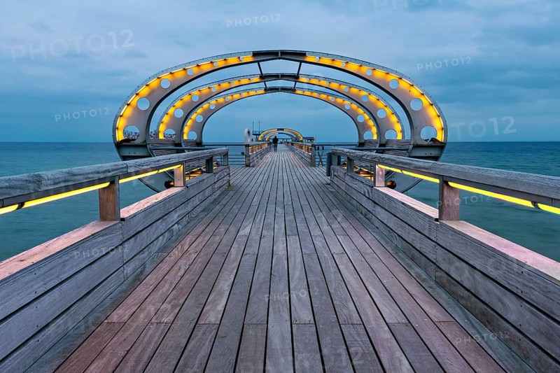 Long exposure of the Kellenhusen pier on the Baltic Sea with yellow illuminated arcades