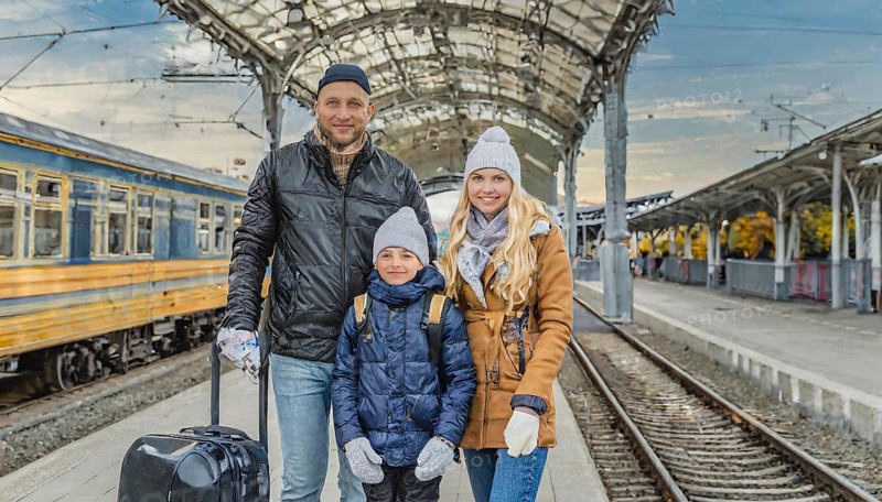 AI generated, A young family wants to travel and waits in the station for the train, 30, 35, years, blond, blonde, man, woman, child, children, 10, 12, modern, modern, suitcase, handbag, winter jacket, white, sneakers, shoes, sexy, attractive, attractive, long-haired, transport, traffic, three people, family