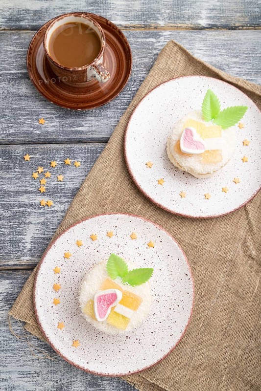 Decorated cake with milk and coconut cream with cup of coffee on a gray wooden background and linen textile. top view, flat lay, close up