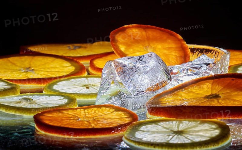 Transparent slices of fresh oranges and lemons on the glass with ice