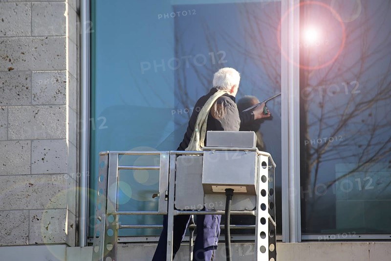 Workers cleaning glass in an office building