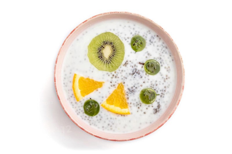 Yogurt with kiwi, gooseberry, chia in ceramic bowl isolated on white background. top view, close up
