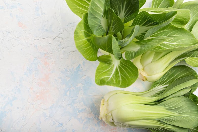 Fresh green bok choy or pac choi chinese cabbage on a white concrete background. Top view, copy space, flat lay
