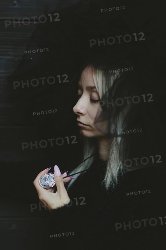A woman's half-hidden face in the shadows, creating a mysterious and thoughtful image