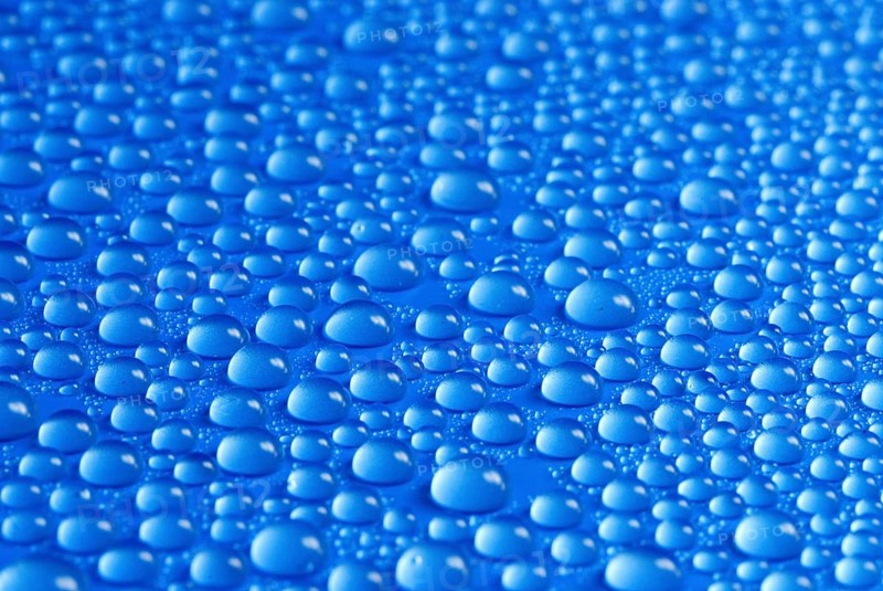 Many small water drops on a blue surface