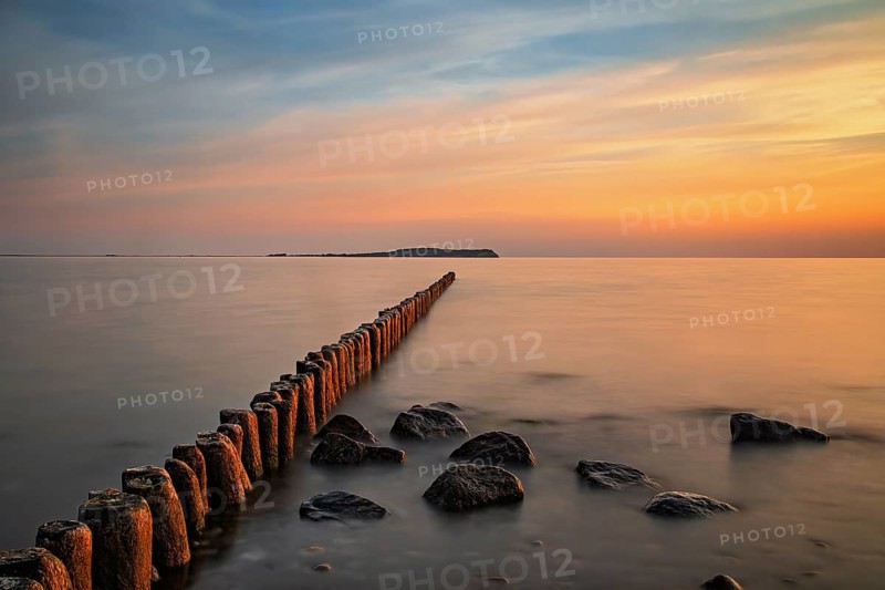 Sunset in Dranske on Ruegen with a view over the groynes to Hiddensee