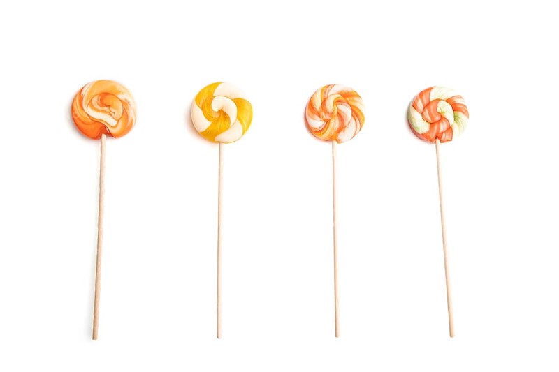 Four lollipop candies isolated on white background. close up, top view, flat lay
