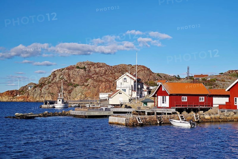 Colourful fishermen's huts nestled against high rocks, small fishing boat, autumn, Vaestra Goetalands Laen, Sweden, Europe