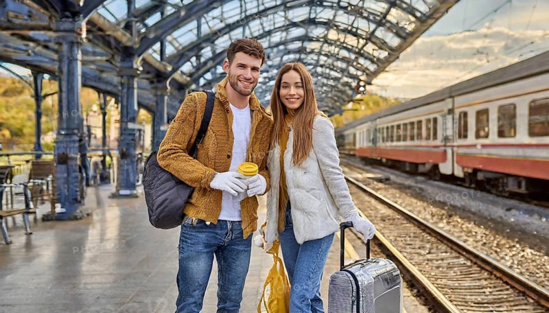 AI generated, A young couple wants to travel and is waiting for the train at the station, 20, 25, blond, blonde, modern, modern, handbag, fur jacket, boots, sexy, attractive, attractive, long-haired, transport, traffic