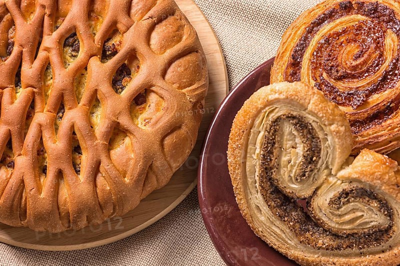 Sweet buns on a wooden board and linen tablecloth